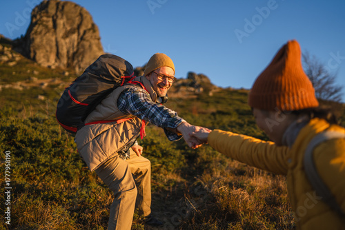 Canvas Print Couple hiking mountains receiving helping hand from partner