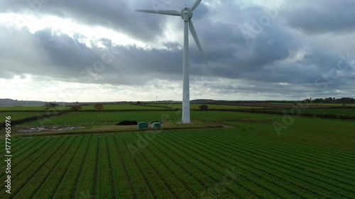 Aerial drone view of single wind turbine windmill in rural green field surrounded by crops and rolling landscapes, green energy generation renewable power plant, Nottingham, United Kingdom, Europe