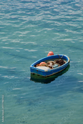 Solitary blue fishing boat in crystal clear turquoise water