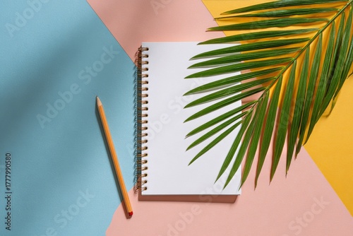 Blank Notebook With Pencil and Green Leaves on Colorful Background at Daytime