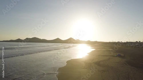 Toma aérea al atardecer en una playa del Perú – vistas panorámicas del mar, las olas y la costa iluminadas por la luz dorada del ocaso