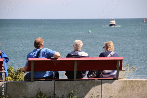 Touristen sitzen auf einer Bank auf der Hochseeinsel Helgoland in Deutschland 