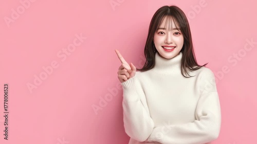 女性がピンク背景で右手で指差す