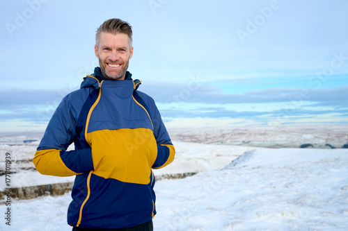 Smiling Middle Aged Male Enjoying Peace and Tranquility of Snowy Hills in Wintertime with Copy Space