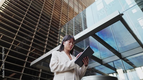 Wallpaper Mural Businesswoman using digital tablet outside office building Torontodigital.ca