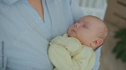 A mother cradles her infant in her arms close up. Concept of late motherhood