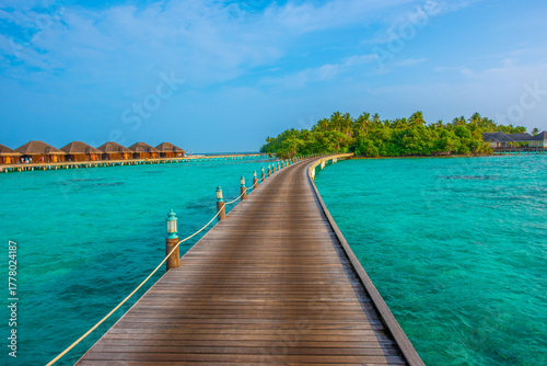 Fototapeta Naklejka Na Ścianę i Meble -  Tranquil closeup calm sea water waves with palm trees. Deck with bungalows. Tropical island beach landscape exotic shore coast. Summer vacation, holiday amazing nature. Relax paradise, Maldives.