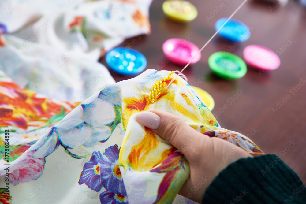 Obraz premium seamstress tailor using beads decorating dress in atelier