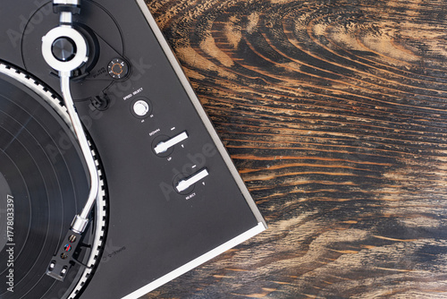 Photography Retro vinyl player with record spinning on wooden background.
