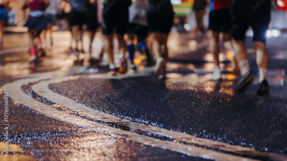 Fototapeta premium Night marathon runners crowd in the rain, sportsmen participants start running the half-marathon in the city streets with night lighting and illumination, group crowd of sportswomen joggers in motion