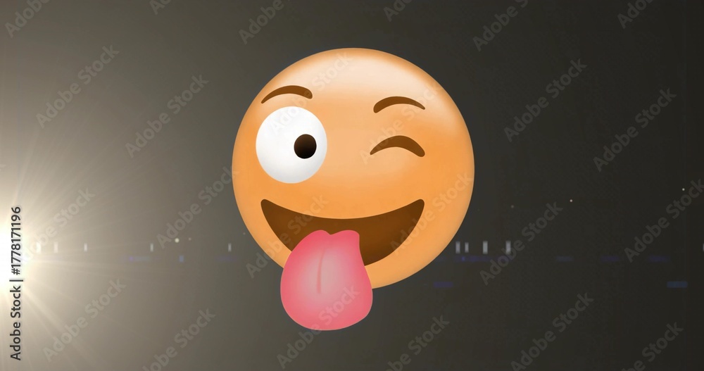 Fototapeta premium Floating cartoon smiley emoji winking and sticking out tongue in dark studio, with spotlight flare