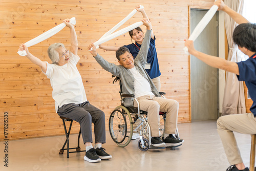 Senior men and women doing exercises and stretching at a nursing home, day care center, and staff
