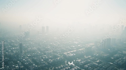 Aerial drone footage of a large city covered with thick smog and haze, cinematic atmosphere, environmental pollution and climate change concept, AI generated, 4K resolution
