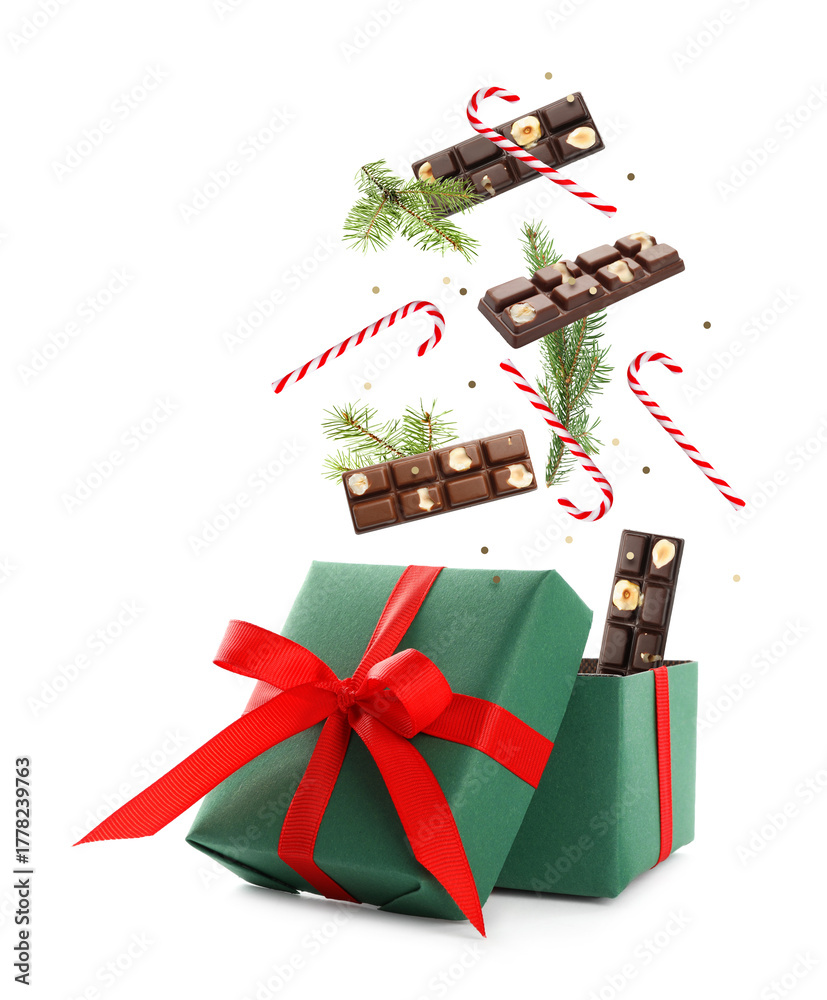 Obraz premium Christmas celebration. Candies falling into gift box on white background