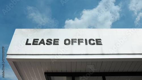 Lease Office word sign displayed on building facade under clear blue sky, representing property rental services, tenant agreements, and real estate management administration.