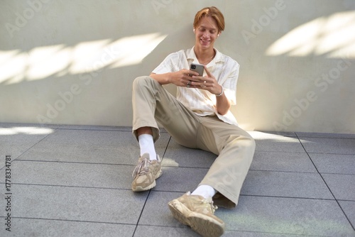 Young Man Enjoys Casual Moments While Texting Outdoors