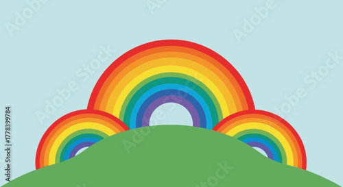 Three colorful rainbows over a green hill under a blue sky.
