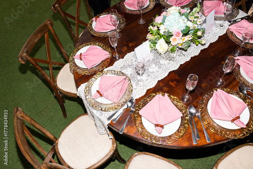 Round wooden table decorated formally for an elegant wedding reception