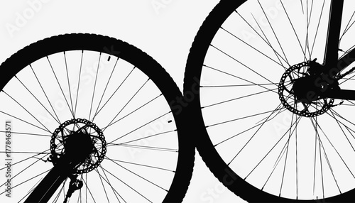 Silhouetted bike wheels and disc brakes against a clean white background, creating an abstract composition