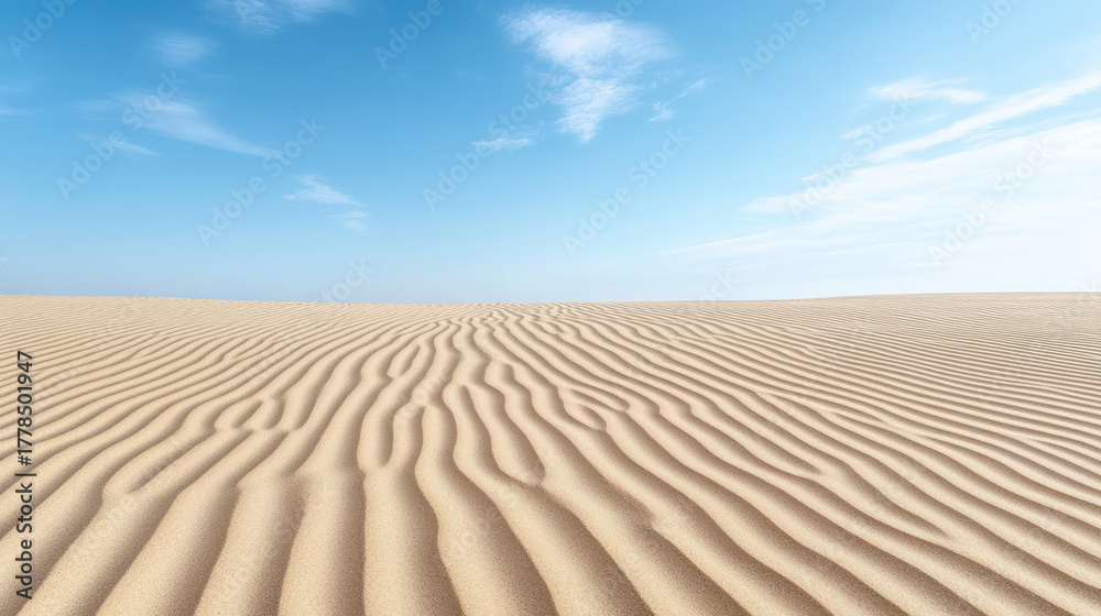 Fototapeta premium Gentle sand ridges create serene landscape under clear blue sky, evoking peace