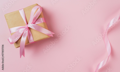 Gift box with ribbon on pink background. Valentine or wedding background.