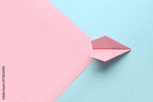 Pink paper plane on color b...