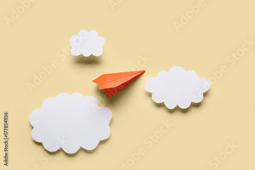 Orange paper plane with clo...