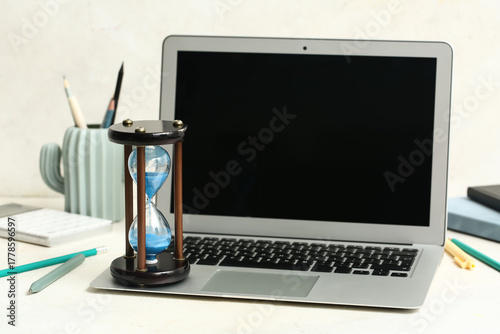 Hourglass with laptop and s...
