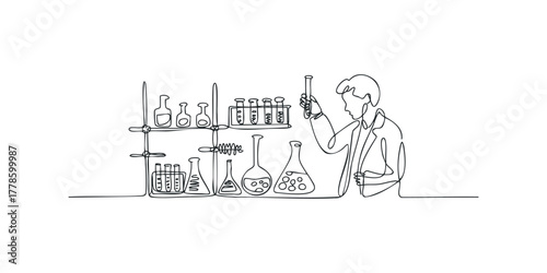 Scientist in lab coat examines vial with glassware on shelves