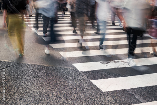 Crowd crossing urban street on zebra lines