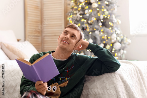 Young man reading book in b...
