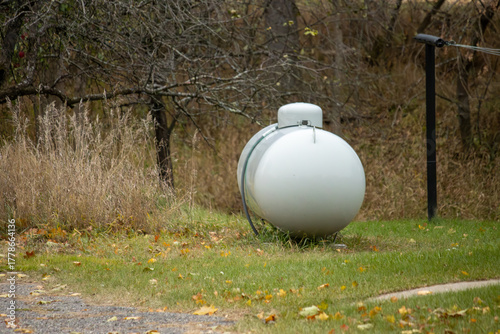 A steel propane tank in the yard