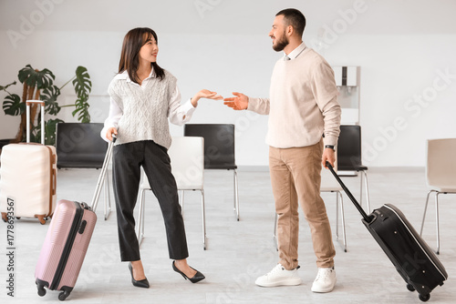 Young couple with suitcases...