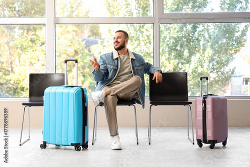 Young man with suitcase wai...