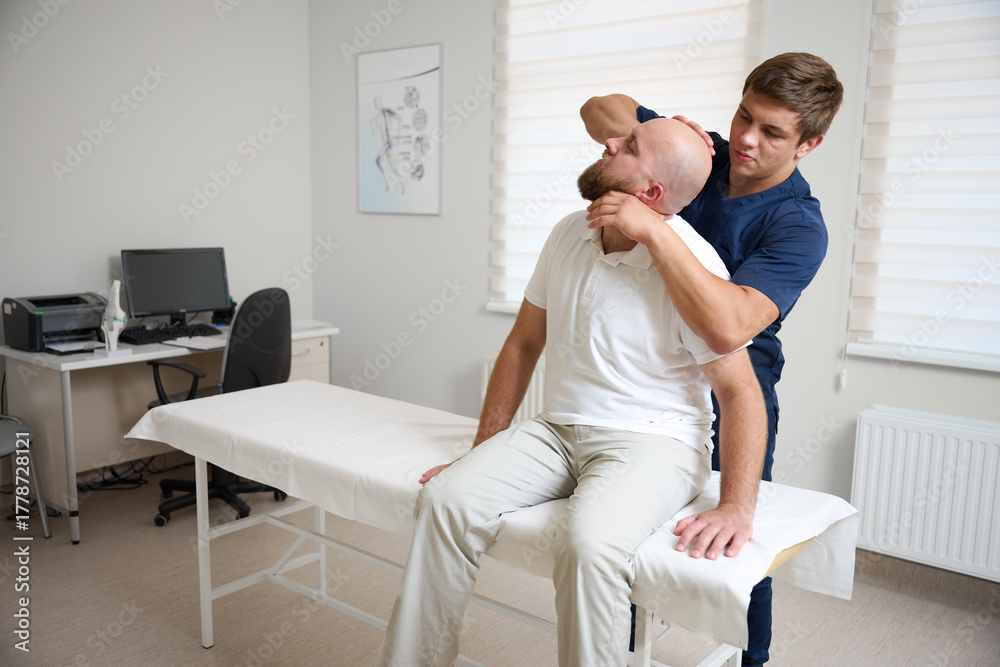 Fototapeta premium Chiropractor adjusting patient's neck in medical clinic. Professional manual therapy, spine alignment, and rehabilitation treatment for pain relief and wellness.