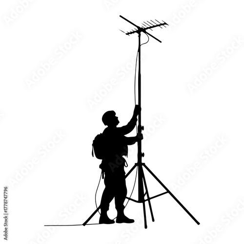Person adjusting antenna on tripod silhouette mast