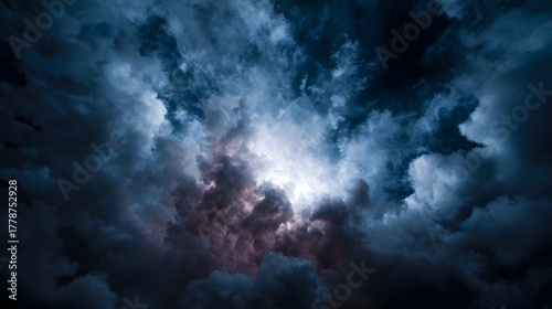 Dark turbulent storm clouds dramatically lit from behind by a brilliant radiant light source creating an atmospheric phenomenon