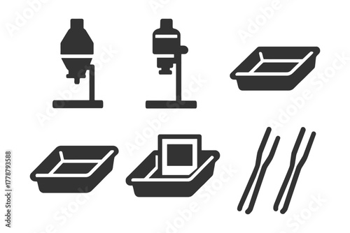 Darkroom equipment set: enlargers, trays, tongs for photographic development.