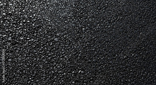 Black asphalt texture with small pebbles, abstract background representing a road surface or construction material for creating depth and detail in designs