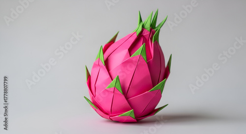 Origami dragon fruit in bright pink, neutral background