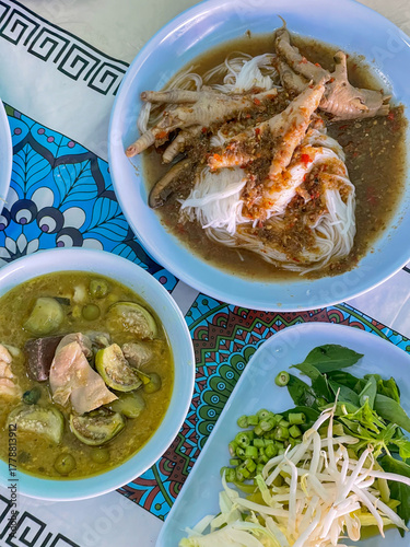 Close up rice vermicelli noodle served with Thai green curry and vegetable.