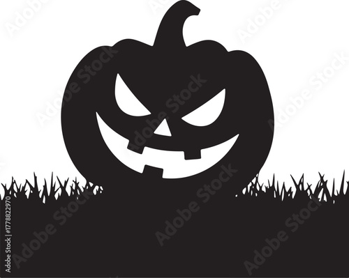 Black silhouette of a carved jack o lantern in grass