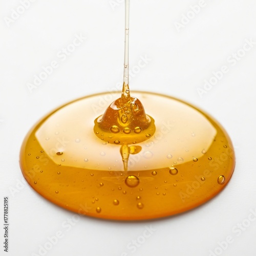 Golden honey dripping and forming smooth liquid texture macro close up