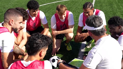 Soccer coach discussing game strategy with team during training