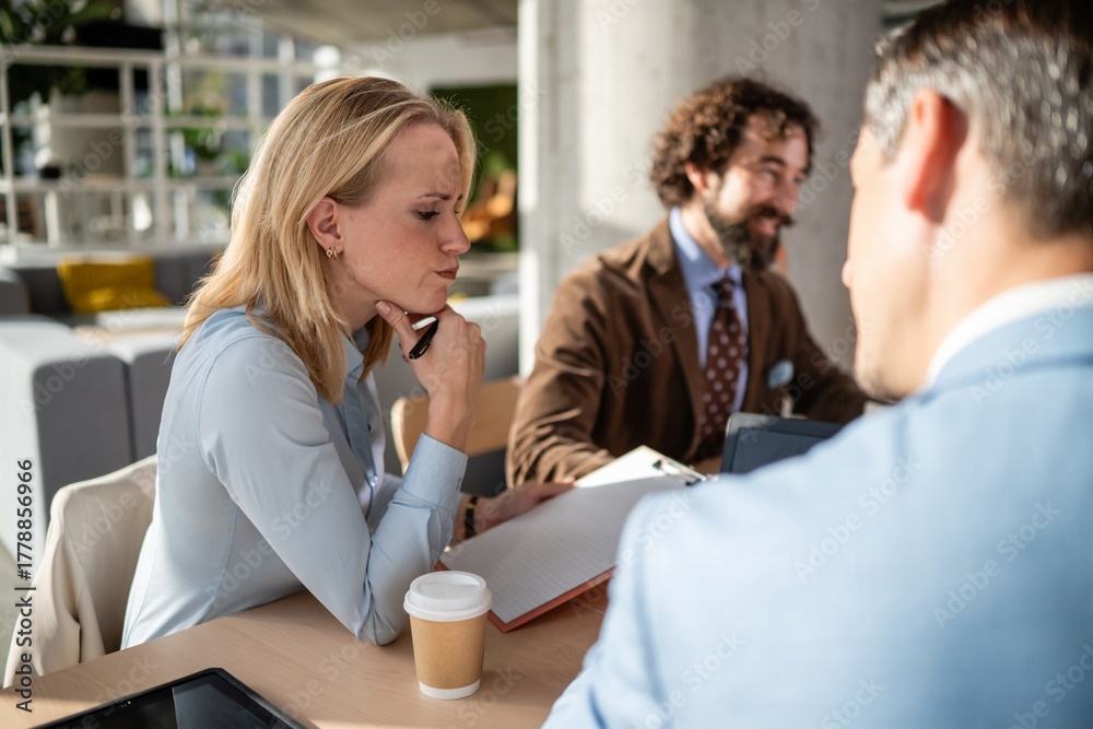 Obraz premium Businesswoman thinking during corporate meeting with colleagues