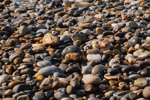 Full frame background of smooth, round sea pebbles in various shades of gray and brown