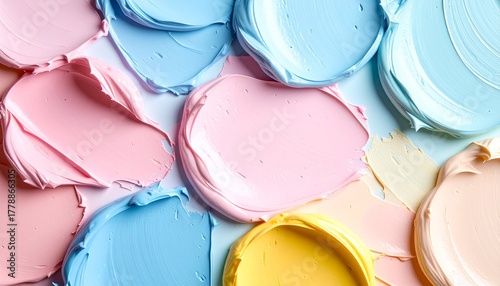 淡いブルー、柔らかなピンク、クリーミーなイエロー、そしてごく薄いブルーといったパステルカラーの絵の具が、平らな表面に厚塗りされたテクスチャのクローズアップです。絵の具の立体感や粘り気が伝わるマクロ撮影で、優しい色の組み合わせ