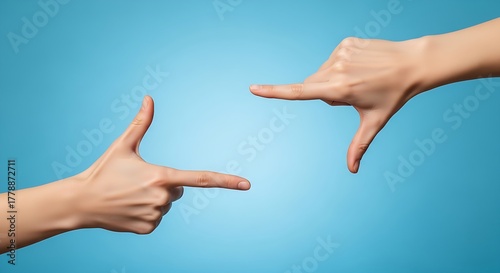 Hands framing a shot on a blue background, creating a rectangular shape