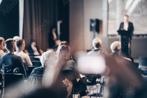 Speaker giving a talk in conference hall at business event. Rear view of unrecognizable people in audience at the conference hall. Business and entrepreneurship concept