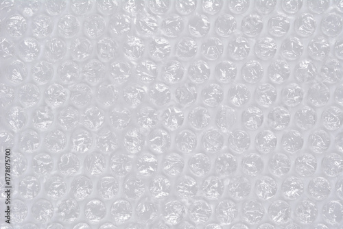 A horizontal, full-frame macro shot of clear plastic bubble wrap, creating a repetitive texture of inflated air pockets